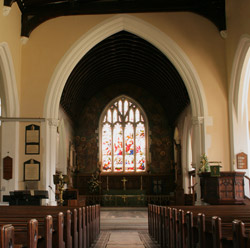 Looking down the aisle to the stained glass window behind altar